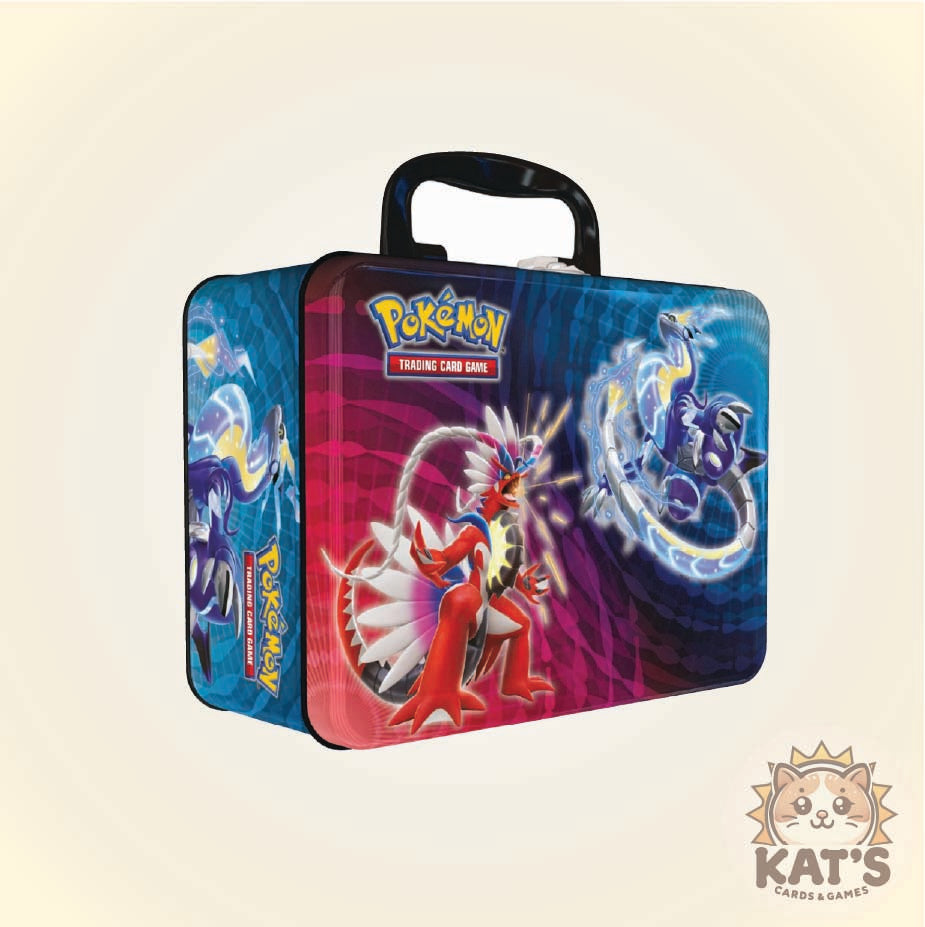 A Pokémon Trading Card Game metal lunch box with a black handle, featuring artwork of Regirock and a blue dragon on a pink and blue gradient front panel, shown on a light beige background.